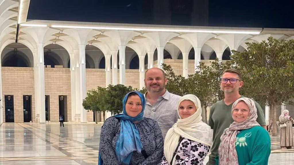tourists standing in the algerian mosque El Djamaâ el-Kebir in a modest dress