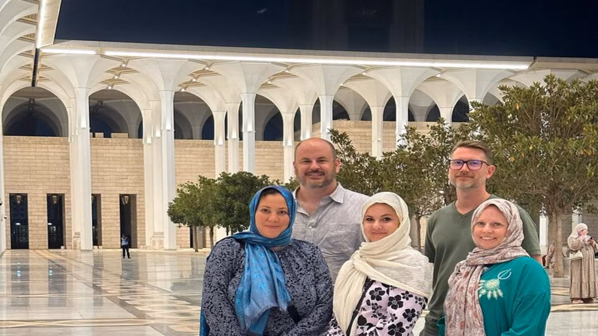 tourists standing in the algerian mosque El Djamaâ el-Kebir in a modest dress